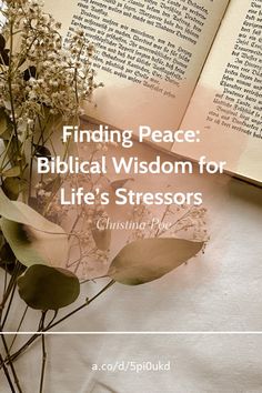 an open book sitting on top of a table next to some flowers and books with the words finding peace biblical wisdom for life's stressors