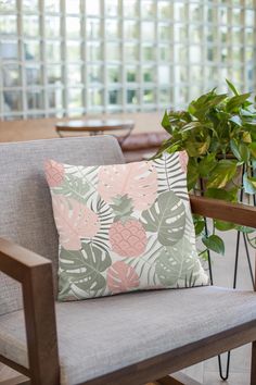 a chair with a pillow on it next to a potted plant