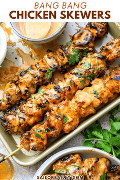 grilled chicken skewers on a tray with sauce and parsley in the background