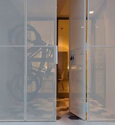 an open door to a room with a bike on the wall and glass partitions