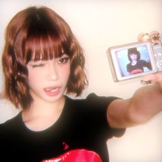 a woman taking a selfie with her cell phone in front of her face and wearing a red boxing glove