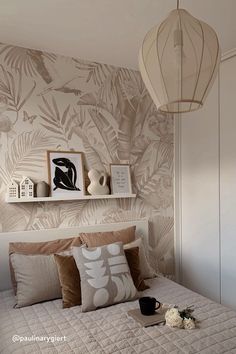 a bedroom with a bed, lamp and pictures on the wall above it is decorated in neutral tones