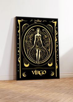 a black and gold virgo poster sitting on top of a hard wood floor