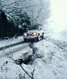 a jeep driving down a snow covered road