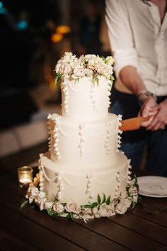 a man and woman cutting a wedding cake