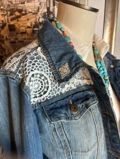 a denim jacket with lace and beads on it