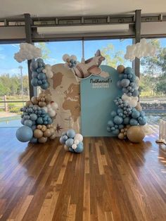 balloon arch with blue and white balloons in front of the entrance to an indoor venue