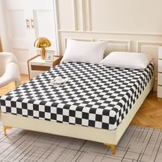 a black and white checkered bedspread on a bed frame in a bedroom