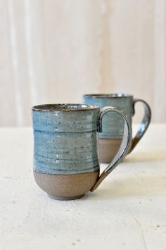 two mugs sitting side by side on a table