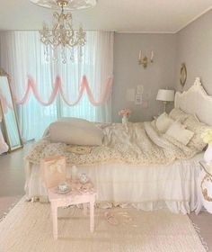 a bed room with a neatly made bed and a chandelier hanging from the ceiling