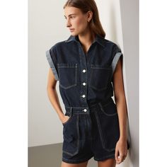 Blue denim (100% Cotton). Romper. Short sleeves. Collared. Front button closure. 32.5" from shoulder to hemline. 9" inseam. Imported. Button-up Denim Vest For Work With Pockets, Short Sleeve Denim Vest With Pockets, Denim Vest With Pockets And Short Sleeves, Collared Denim Top With Pockets, Trendy Collared Denim Jumpsuit, Casual Denim Vest With Snap Buttons For Work, Casual Workwear Denim Vest With Snap Buttons, Blue Button-up Denim Vest For Work, Relaxed Fit Denim Top With Buttoned Pockets For Work