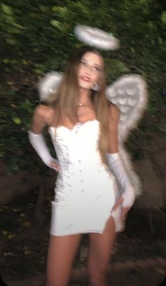 a woman in a white dress and angel wings