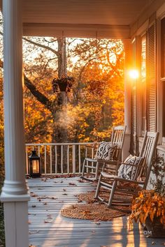 a porch with rocking chairs and fall foliage