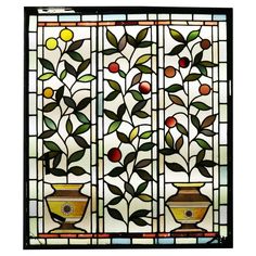 a stained glass window with vases and fruit on it