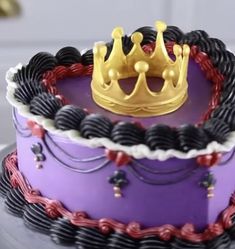 a purple cake with a gold crown on top and black icing around the edges