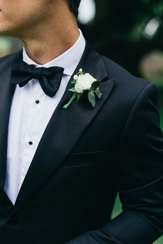 a man in a tuxedo with a boutonniere on his lapel