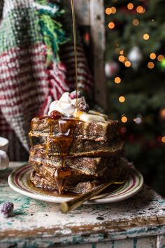 a stack of waffles with syrup and ice cream