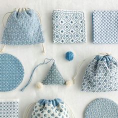 several blue and white bags are shown with balls, yarns, and drawstring