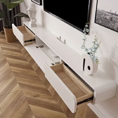 an entertainment center with two drawers and a flat screen tv mounted on the wall above it