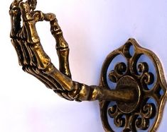 an antique brass hook with decorative design on it