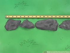 three rocks and a measuring tape on a green surface