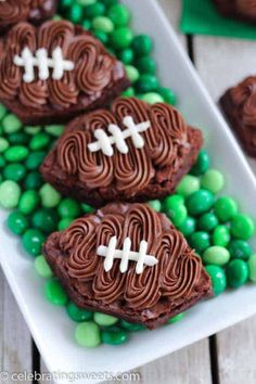 chocolate football cookies on a plate with green candies and shamrocks in the background