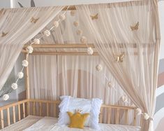 a canopy bed with white curtains and pillows on it's sides, in front of a striped wall