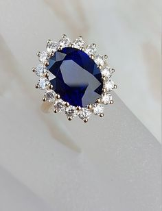 a ring with a blue stone surrounded by white diamonds