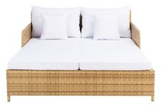 a wicker bed with two white pillows on the top and bottom, in front of a white background