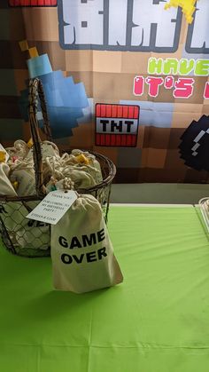 a basket full of game over bags sitting on top of a green tablecloth covered table