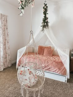 a white bed sitting in a bedroom next to a pink blanket on top of a chair