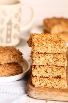 three oatmeal bars stacked on top of each other next to a cup of coffee