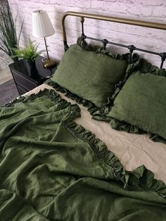 a bed with green sheets and pillows on it