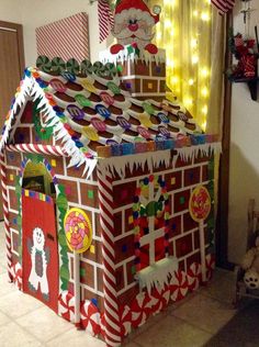 a house made out of cardboard and decorated with christmas decorations