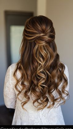 the back of a woman's head with long wavy hair in half - up style