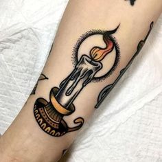 a tattoo on the leg of a person with a candle and other items around it