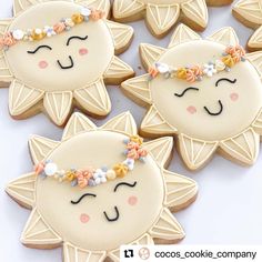 decorated cookies in the shape of cats with flowers on their heads and eyes are displayed next to each other