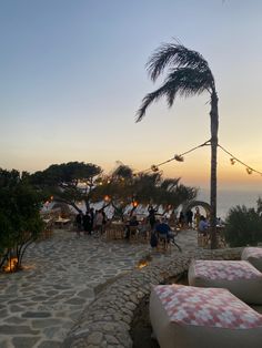 an outdoor seating area with palm trees and lights