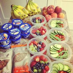 several plastic containers filled with different types of fruits and vegetables on top of a counter