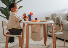 a small child sitting at a table playing with toys