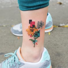 a woman's foot with a colorful flower tattoo on her left side calfocks