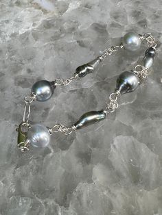 Tahitian Keshi (creamy silver/blue) and South Sea (creamy white) pearl bracelet in 925 sterling silver chain.  Tahitian baroque pearls (2) measure around 9-11 mm.  Tahitian Keshi pearls (3) measure 12-15mm in length.  South Sea pearls (2) measure 9-10 mm.  The combination of pearls gives it an organic, natural beauty! White Pearl Bracelet, Keshi Pearls, South Sea Pearls, Sea Pearls, 925 Sterling Silver Chain, Tahiti, Baroque Pearls, Silver Blue, Creamy White