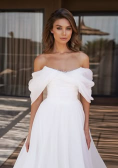 a woman in a white dress posing for the camera