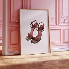 a pair of high heeled shoes sitting on top of a wooden floor next to a pink wall