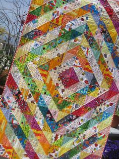 a multicolored quilt is shown with many different colors and patterns on it's sides