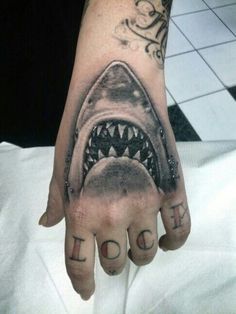 a hand with a shark's teeth on it and the word fear written in black ink