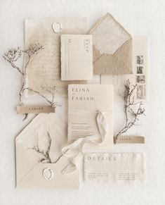 the wedding stationery is laid out on top of each other, including envelopes and cards