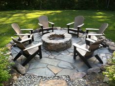 an outdoor fire pit with chairs around it