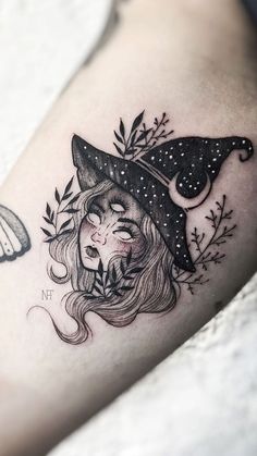 a woman's leg with a tattoo on it and an image of a witch