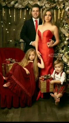 a family posing for a christmas photo in front of a christmas tree